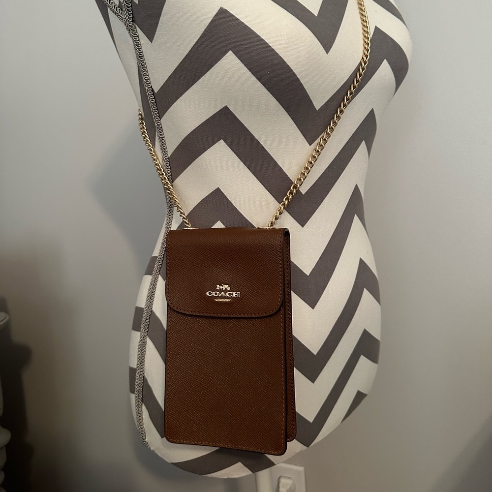 Brown Coach phone wallet on a chain.